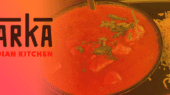 A food dish featuring a bowl of tomato-based curry with herbs and a side of rice. The text reads "Tarka Indian Kitchen.