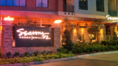 Exterior view of Seasons 52 Fresh Grill restaurant with illuminated signage and landscaped surroundings.