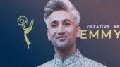 Person with silver hair and patterned jacket stands in front of a backdrop with Creative Arts Emmys logos.