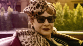 A woman wearing sunglasses and a leopard print hat.