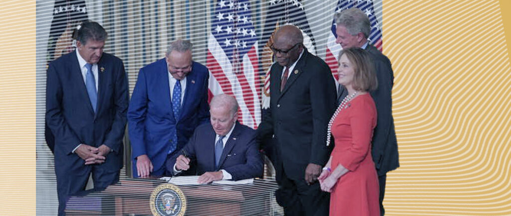 Joe Biden signing documents on a podium