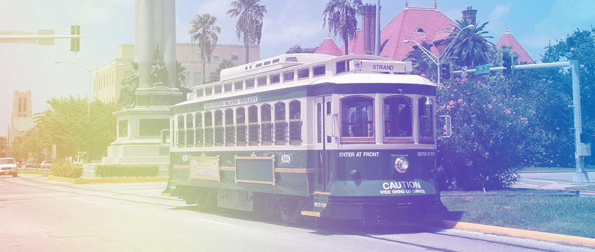 A trolley car is traveling down the street.