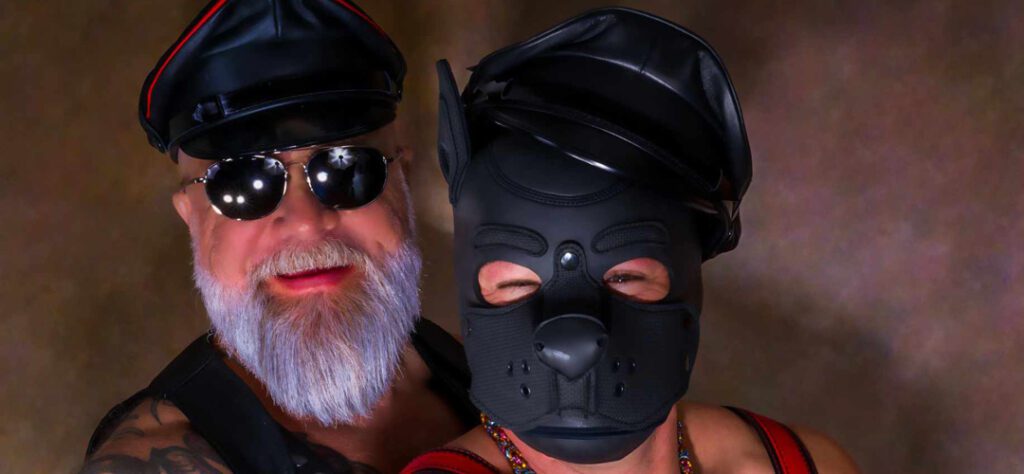 A man and woman wearing leather masks.