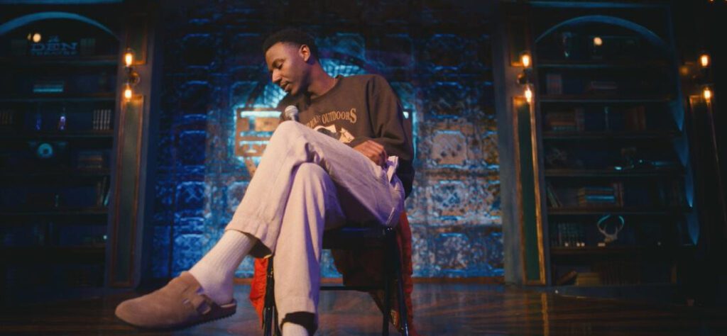 A man sitting on top of a chair in front of a microphone.