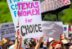 A woman holding up a sign that says texas women for choice.